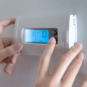 Hand Press Indoor Room Thermostat To Lower The Temp