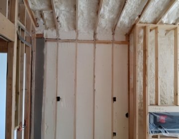 Attic insulation installed with spray foam between rafters to prevent heat loss and air leakage
