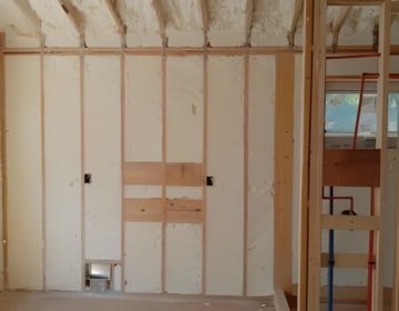 Completed wall insulation with closed cell spray foam creating an airtight and moisture-resistant barrier