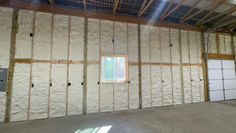 Pole barn wall finished with spray foam insulation around a window