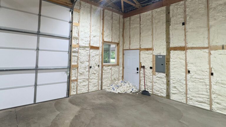 Pole barn garage walls finished with spray foam insulation next to the overhead doors