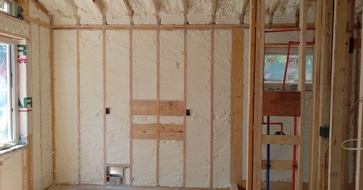Metal building wall insulated with spray foam